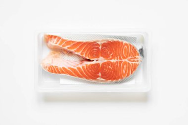 Beyaz arka planda plastik ambalajlı somon balığı, soğuk balık.