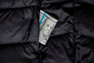 Siyah ceketin cebinde bir yığın yüz dolarlık banknot, yakın plan, nakit dış giysi.
