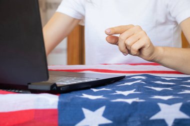 Masada dizüstü bilgisayarla çalışan bir kız. Amerikan bayrağı, serbest çalışan, evden online çalışan bir kız.