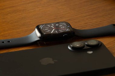Ukrayna Dnipro 04-06-2025 Apple Watch ve iPhone 16 ahşap bir yüzey üzerinde, modern aletler evde masada.