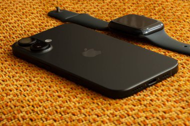 Ukrayna Dnipro 04-06-2025 Apple Watch ve iPhone 16 kahverengi kumaş üzerine uzanır.