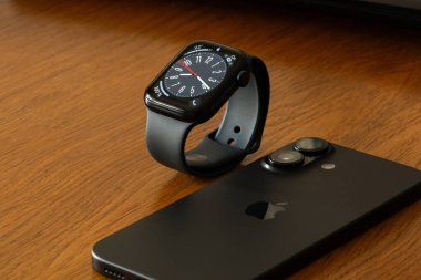 Ukrayna Dnipro 04-06-2025 Apple Watch ve iPhone 16 ahşap bir yüzey üzerinde, modern aletler evde masada.