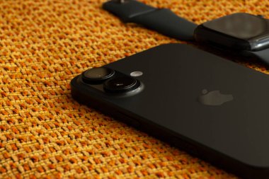 Ukrayna Dnipro 04-06-2025 Apple Watch ve iPhone 16 kahverengi kumaş üzerine uzanır.
