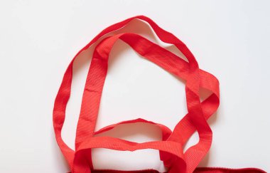 Beyaz arkaplanda kırmızı yeniden kullanılabilir market poşeti saplarının yakın plan görüntüleri