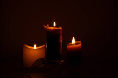 Karanlık bir arka planda mumlar, akşam ışıkları.