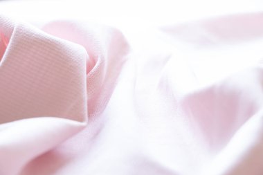 Açık pembe kumaş dokusu yakın plan, dalgalı arkaplan yüzeyi