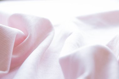 Açık pembe kumaş dokusu yakın plan, dalgalı arkaplan yüzeyi