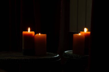 Yanan iki mum aynanın yanındaki sandalyede durur ve aynanın yansımasında mumlar karanlıkta görünür, mum alevi.