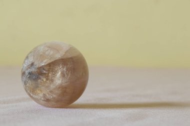 Ay taşı, masa üzerinde kuvars. Sarı arka planda. Koleksiyon ve iç mekan için, değerli taş.
