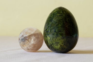 Ay taşı, kuvars ve zümrüt jasper sarı arka plandaki bir masada yumurta şeklinde, değerli taşlar, koleksiyon.