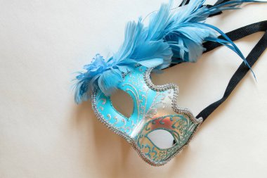 Beyaz arka planda mavi ve siyah tüylü açık mavi karnaval maskesi, bir maskeli balo için dekoratif aksesuar.