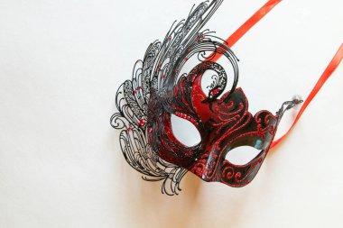 Beyaz arka planda kırmızı ve siyah karnaval maskesi, maskeli balo için dekoratif aksesuar.