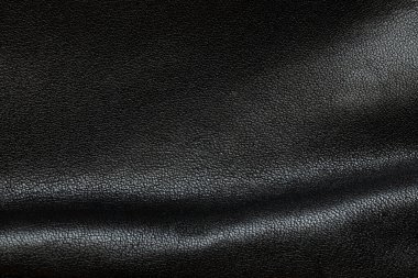 Katlanmış ve gölgeli siyah deri arka plan, kadın deri çantası.