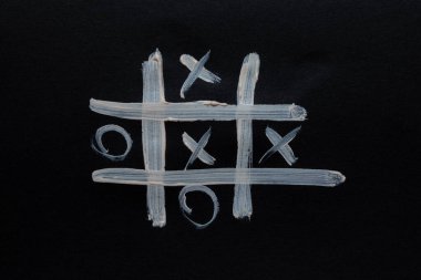 Açık renkli tahta oyunu tic-tac-toe ile siyah kağıt, oyun ve hobi üzerine çizilmiş