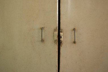 Ukrayna 'da bir dairede beyaz boya ve demir saplı eski mutfak dolapları.