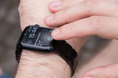 Ukrayna Krivoy Rog 08 / 23 / 2025 - Apple Watch serisi 9 akıllı saat takan bir adamın yakın çekimi zaman, tarih, hava ve saat şarj