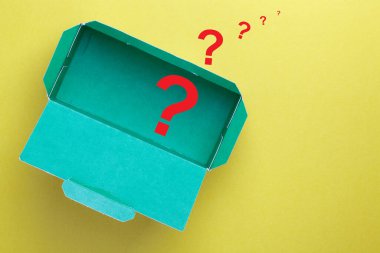 Carton box with question mark on yellow background. Mystery box concept.