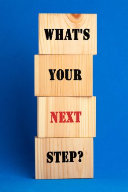 What is your next step symbol with wooden block on blue background.  clipart