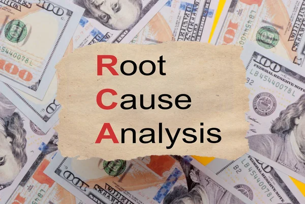 Background of dollar bills with root cause analysis (RCA) text written with marker on old torn paper. Selective focus