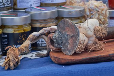 Yerel bir markette sergilenen eşsiz sarımsak örgüsü canlı aşçılık otları ve ürünleri sergiliyor.