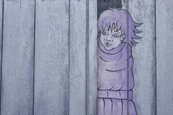 Pastel mor bir duvar resmi, geniş gözlü ve dikenli saçlı, eskimiş, açık mavi ahşap döşemeleri soyan, tuhaf ve kırsal bir etki yaratan bir çocuk figürü..