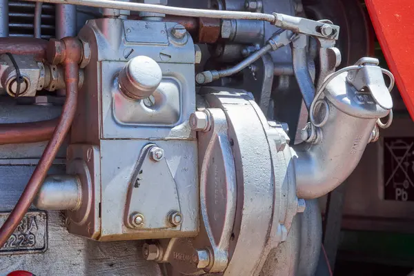 Endüstriyel bir makinede çeşitli gümüş ve bakır tonlu metal bileşenler, borular ve cıvataların detaylı yakın çekimi, karmaşık mekanik parçaları ve dokuları vurguluyor..