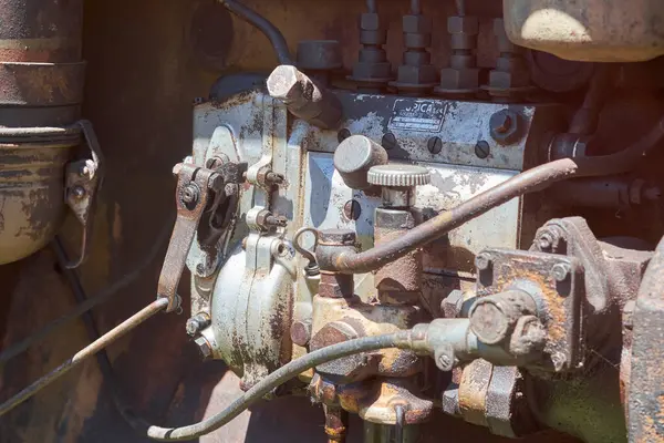 Yoğun paslanmış ve kirli bir mazot motorunun yakıt pompasının ve çeşitli mekanik bileşenlerin detaylı bir yakın çekimi, zamanın yıpranması ve endüstriyel kullanımını gösteriyor..