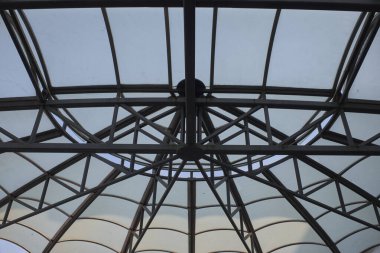 Camdan ve metal kubbeden oluşan karmaşık geometrik desenlerin yukarı bakımı modern mimari tasarımı sergiliyor..