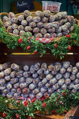 Geleneksel bir İtalyan şarküteri olan sanatsal iyileştirilmiş salam. Gurme et ürünü İtalya 'da bir açık hava pazarında istiflendi.