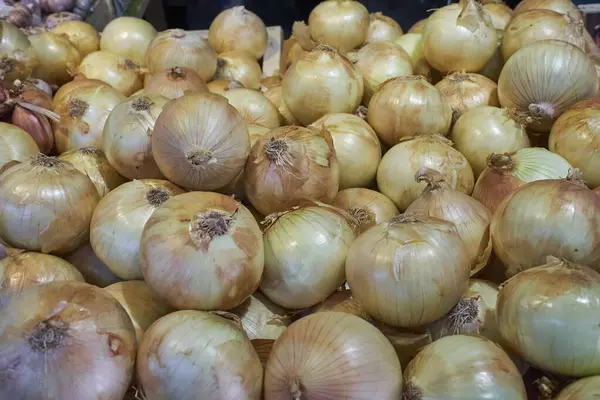 Canlı sarı soğan yığını bir çiftçi pazarında sergileniyor. Mutfak, tarım ya da sağlıklı gıda içeriği için mükemmel.