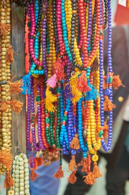 Markette çeşitli renklerde püskülleri olan canlı el yapımı boncuklu kolyeler. Geleneksel etnik takılar ruhani ya da bohem moda aşıkları için idealdir..