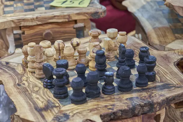 Kırsal, doğal bir tahta üzerinde el yapımı ahşap bir satranç seti. Strateji, zanaat, gelenek ve masa oyunu kavramları için mükemmel..