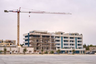 Bulutlu bir günde vinç ve iskelesi olan kentsel yerleşim sitesi