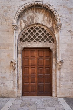 Karmaşık oyma taş kapılar, dekoratif kemerler ve taş kaldırım üzerindeki geleneksel kahverengi ahşap kapılar içeren antik kireçtaşı geçidi.