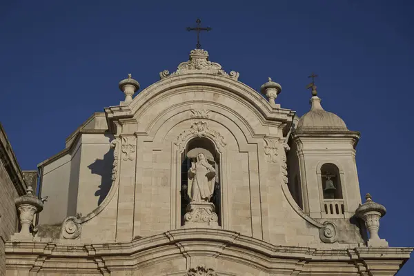 Tarihi barok katedrali. Detaylı oyma taş işçiliği, aydınlık günde azize heykeli, çan kulesi ve dekoratif unsurlar.