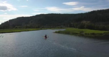 Kuzey Idaho 'daki Coeur d' Alene Gölü 'ndeki sığ bataklıklarda iki adam kürek çekiyor.