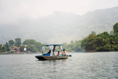 Bhimtal, Uttarakhand, Hindistan - 2022 dolaylarında, Kaşmir bhimtal naukuchiatal 'da aile fertlerini ormanlık alanlarda perdeleri olan kapalı salın tadını çıkarırken gösteren bir fotoğraf.