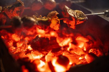 Et ve sebzeli tavuk, sokak yemekleri için baharatlı popüler Hint yemekleri yapmak için mangal odunu ve kömür ateşinde kızartılıyor.