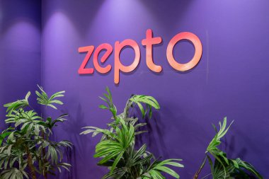Gurgaon, Delhi, India - circa 2023: Online startup delivery app Zepto logo on purple wall with plants below it showing hyperlocal deivery