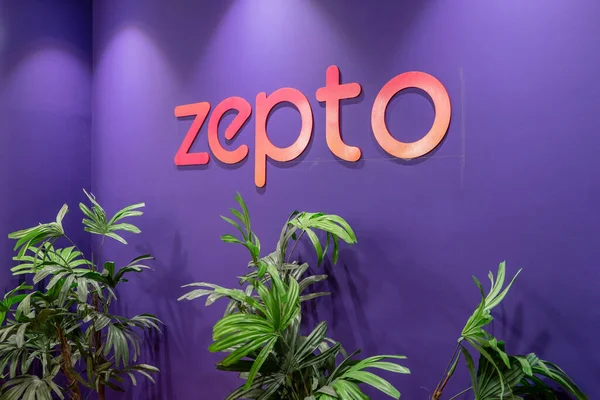 stock image Gurgaon, Delhi, India - circa 2023: Online startup delivery app Zepto logo on purple wall with plants below it showing hyperlocal deivery