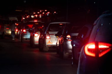 Night shot of car lights stuck for large distance in traffic jam at night on a narrow road in the Indian hill station of Manali Kullu himachal Pradesh India popular tourist destination clipart