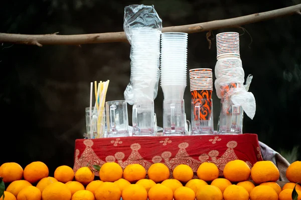 oranges kinnu citrus fruit piled up at a roadside stall with glasses for juice to be squeezed fresh and served on road side in hot summar