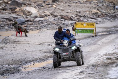 Manali, Hindistan - 2023 dolaylarında lahul spiti 'deki kalabalık küçük gıda mağazalarını, karla kaplı yolda ailesiyle ATV' ye binen maceralı sporları ve uzaktaki Himalay zirvelerini gösteriyor.