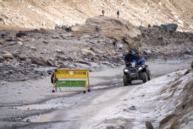 Manali, Hindistan - 2023 dolaylarında lahul spiti 'deki kalabalık küçük gıda mağazalarını, karla kaplı yolda ailesiyle ATV' ye binen maceralı sporları ve uzaktaki Himalay zirvelerini gösteriyor.