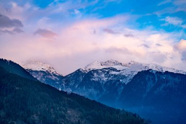 Muson bulutları kar üzerinde ilerlerken Himalaya dağlarını kapladı. Mavi turuncu günbatımı gündoğumu ışığı Kelemeli Manali Vadisi Hindistan 'ın üzerindeydi.