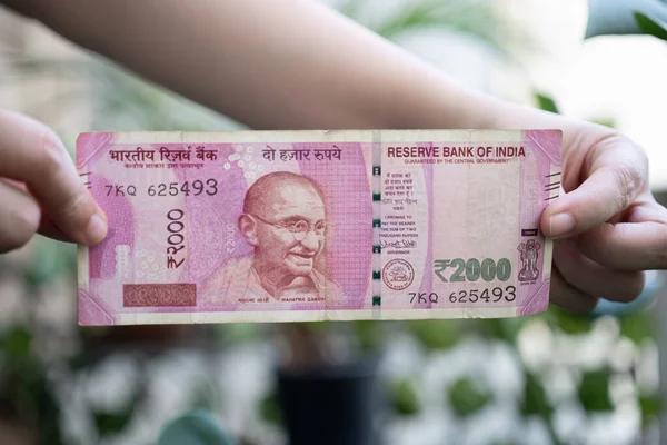 2000ルピーのインドの銀行券を保有している女性は インドで黒いお金を減らすためにデモ化を通じて流通から削除されました — ストック写真