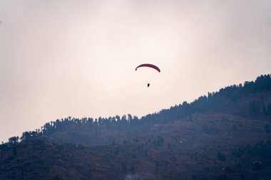 Günbatımında gökyüzüne ve dağlara karşı, kopya alanı ve parlak renkleriyle yol alan para Hindistan 'ın tepe istasyonunda özgürlüğü gösteriyor.