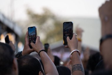 İnsanların el kaldırmasını ve cep telefonlarıyla etkinlik kaydetmesini bir partinin, DJ 'in, konserin ya da Hindistan festivalinin keyfini çıkarmasını.