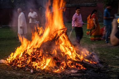 Jaipur, Rajasthan, Hindistan - 14 Ocak 2023: Hindu Holi Lohri festivalinde insanlar büyük bir ateş etrafında dans ederek renk festivalini, iyi bir hasatı ve kışın sonunu kutluyorlar.