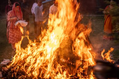 Jaipur, Rajasthan, Hindistan - 14 Ocak 2023: Hindu Holi Lohri festivalinde insanlar büyük bir ateş etrafında dans ederek renk festivalini, iyi bir hasatı ve kışın sonunu kutluyorlar.